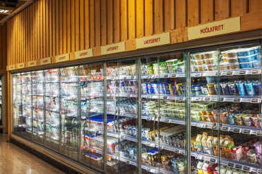 Marketin buzlu bölümünde çeşitli süt ürünleri ve cam kapılı soğutucularda düzenli laktozsuz ürünler sergileniyor.. 