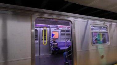 Lexington Bulvarı 63. Cadde istasyonundaki metro treni, kapılar kapanıyor ve Jamaika 179. Cadde istasyonuna doğru tren kalkıyor. New York 'ta. ABD. 