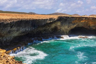 Karayip dalgalarının çöl manzarasıyla buluştuğu Aruba 'daki Arikok Ulusal Parkı' nın Rocky sahili..