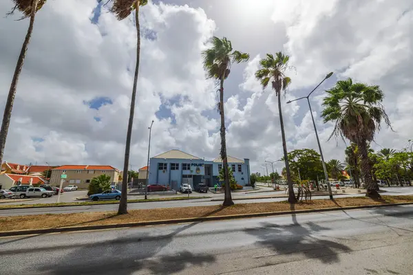 stock image Police station building in Willemstad, Curacao surrounded by palm trees under cloudy sky.