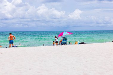 Atlantik Okyanusu 'nda yüzen ve arka planda bulutlu gökyüzü olan güzel bir Miami Sahili manzarası. Miami Plajı. ABD.