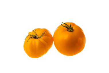 Beyaz arka planda izole edilmiş iki sarı domatesin yakın çekim görüntüsü.