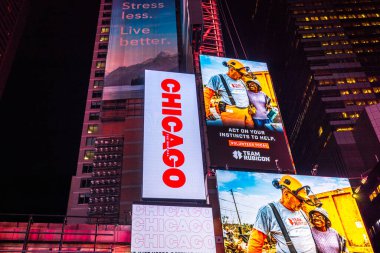 Close-up view of Manhattan skyscrapers at night on Times Square with illuminated billboards featuring Chicago musical. New York. USA.  clipart