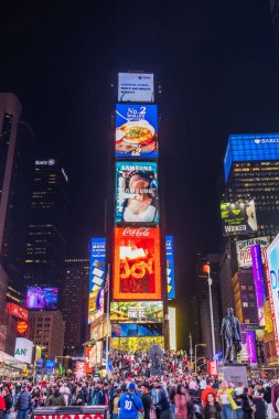 Crowded Times Square at night with vibrant digital billboards and illuminated advertisements. New York. USA.  clipart