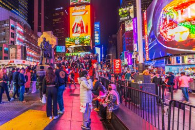 Yayalar, kırmızı merdivenler ve LED panellerle Times Meydanı 'nın gece görüşü. - New York. ABD. 