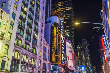 Aydınlanmış Madam Tussauds binasının gece vakti Times Meydanı, New York City 'deki parlak reklam tabelaları ve canlı şehir ışıklarıyla çevrili görüntüsü. - New York. ABD. 