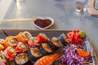 Çok güzel bir suşi tabağı, çeşitli ekmekler, turşulu zencefil, wasabi ve yemek çubukları eşliğinde tepside servis edilen sos. Curacao.