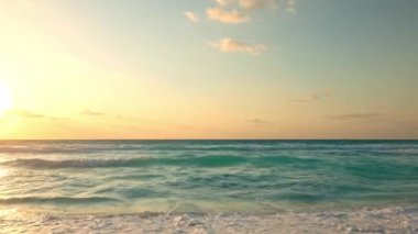 Turkuaz Karayip deniz dalgaları, şafak vakti Meksika 'nın kumlu sahillerine doğal bir sesle çarpıyor..