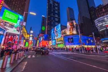 Geceleri Times Meydanı 'nda parlak reklam panoları, aydınlatılmış şehir ışıkları, kalabalık caddelerde arabalar ve yayalar, New York şehri manzarası. - New York. ABD.
