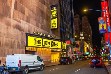 Exterior view of the Minskoff Theatre featuring 'The Lion King' musical signage on a quiet street in New York City at night. New York. USA.  clipart