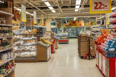 Ekmek vitrinleri ve ürün raflarıyla süpermarket bölümünün iç görünümü. 