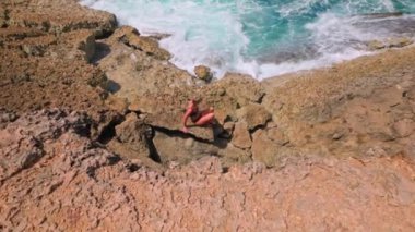 Mayo giymiş bir kadın Aruba 'nın Karayipler kıyılarında parlak güneşin altında çıplak ayakla yürür.. 