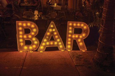 Geceleyin, Collins Bulvarı, Miami Plajı 'nda ışıklı bar tabelası. ABD. 