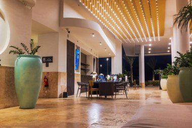 Curacao 'da gece dekoratif tencereleri ve çevre aydınlatması olan modern otel lobisi. Willemstad. 