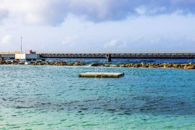 Curacao adasındaki Karayip Denizi manzaralı yanaşma gemileri için rıhtım, yüzmek için yüzen küçük bir platformun yanında.