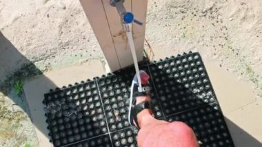 Sandalet giyerken kumsalda yüzdükten sonra açık deniz duşu altında ayak yıkamak.. 