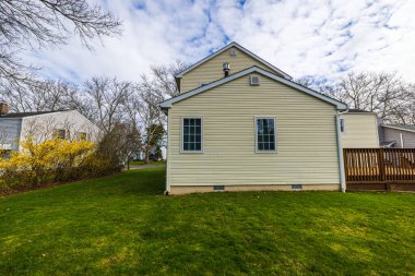 Bahar mevsiminde yeşil çimenli ve ahşap güverteli modern villa manzarası. New Jersey 'de. ABD.