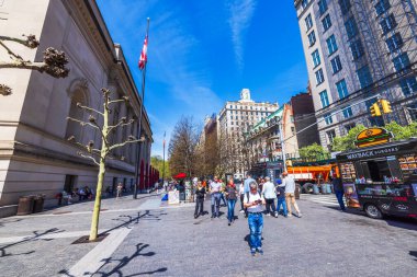 İnsanlar Metropolitan Müzesi 'nin dışında güneşli bir günün tadını çıkarıyor. Arka planda yemek kamyonları ve şehir manzarası var. - New York. ABD.