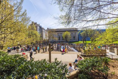 Central Park 'taki Antik Oyun Bahçesi' nde oynayan çocuklar, Met Müzesi ve etrafındaki ağaçların manzarasıyla. - New York. ABD. 