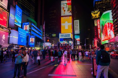 Times Meydanı, New York City 'de canlı bir gece sahnesi. Parlak reklam panoları, kalabalık sokaklar ve fotoğraf çeken turistler. - New York. ABD. 