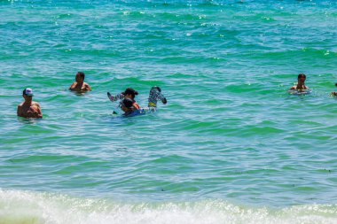 İnsanlar güneşli bir günde Miami Sahili 'nin Atlantik Okyanusu' nda turkuvaz sularında yüzüyor ve dinleniyorlar. Miami Plajı. ABD.