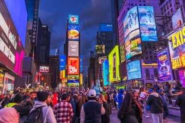 Times Meydanı 'ndaki gece sahnesinde kalabalık, renkli reklam panoları ve New York' ta parlak neon ışıklar var. - New York. ABD. 