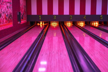 Neon ışıkları ve bowling lobutlarıyla bovling pisti şeritleri, canlı bir atmosfer yaratıyor..