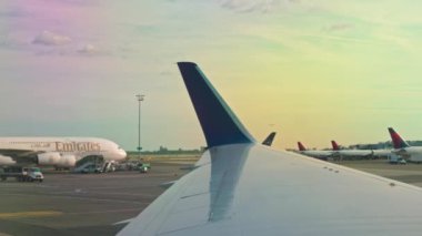 Günbatımında gökyüzü olan uçak penceresinden görülen Emirates uçağının görüntüsü. Miami mi? ABD. 