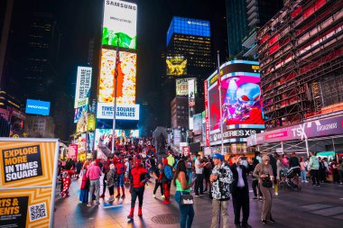 Times Meydanı geceleri kalabalık, renkli reklam panoları ve neon ışıkların altında canlı reklamlarla dolup taşıyor. - New York. ABD.