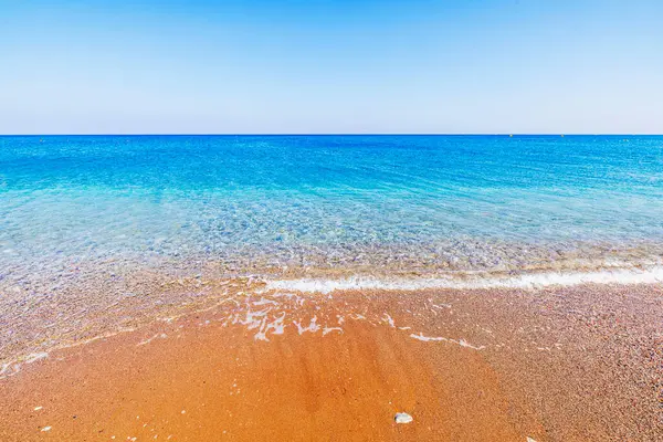 Yunanistan 'ın Rodos adasında Ege Denizi' nin berrak turkuaz suları yavaşça altın kumlu plajları kaplıyor.