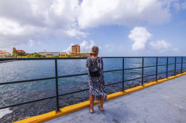 Karayip Denizi 'ne bakan Willemstad, Curacao' daki rıhtımda cep telefonuyla fotoğraf çeken bir kadın.. 