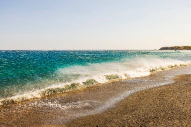 Offshore wind effect with waves pushed back from shore, creating smooth sea surface and rippling patterns. Greece. clipart