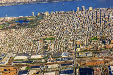 Konut binaları, yeşil parklar ve Hudson Nehri 'nin arka planında yoğun nüfuslu kentsel alanın havadan görüntüsü. New Jersey 'de. ABD.