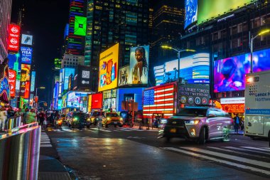 Gece Times Meydanı 'nda Amerikan bayrağı vardı. Amerikan Silahlı Kuvvetleri istasyonunda, canlı reklam panoları ve bulanık araba ışıkları vardı. - New York. ABD. 