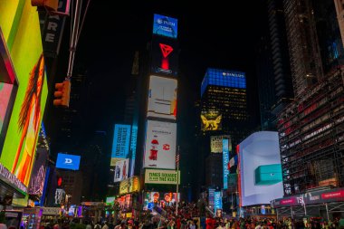 New York 'taki Times Meydanı' nın gece manzarası ışıklı reklam panoları, reklamlar ve gece gökyüzü altındaki turist kalabalıklarıyla dolu. - New York. ABD. 