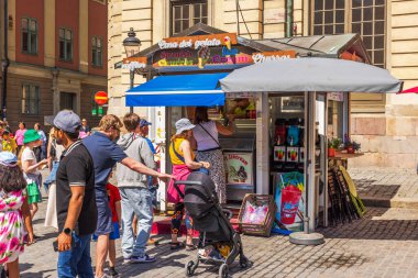 Dondurma büfesi, şehir merkezinde parlayan güneş ışığı altında kaldırım taşı sokağında sırada bekleyen insanlarla dolu.. 