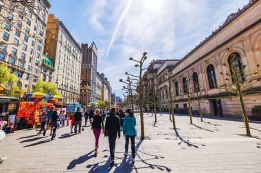 Baharda Metropolitan Sanat Müzesi yakınlarındaki sokak manzarasında insanlar, ağaçlar ve yemek arabaları var. - New York. ABD. 