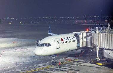 Delta Havayolları uçağı gece operasyonları sırasında Newark Liberty Uluslararası Havaalanı 'nın kapısına yanaştı. New Jersey, ABD. 