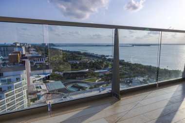 Modern balkondan panoramik tropik kıyı şeridi manzarası sakin mavi karayip sularına bakan cam korkuluklar. Cancun. Meksika. 
