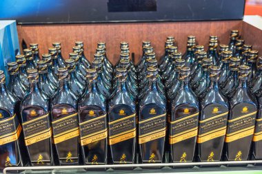 Johnnie Walker 'ın yakın çekim görüntüsü. Çift siyah viski şişeleri vitrinlerde sergilenmek üzere düzgünce dizilmiş..