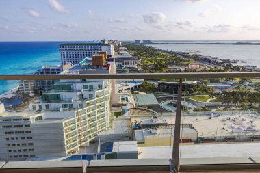 Turkuaz Karayip Denizi manzaralı yüksek balkon oteli, modern otel binaları ve tropikal yeşil manzara. Cancun. Meksika. 