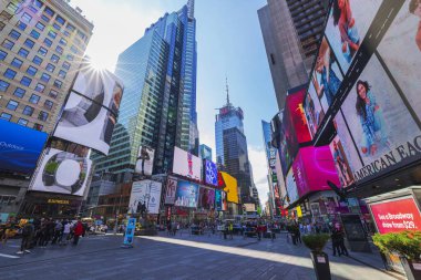 Times Meydanı, yüksek binalar ve güneşli gökyüzünün altında canlı dijital reklam panoları olan insanlarla doluydu. - New York. ABD. 