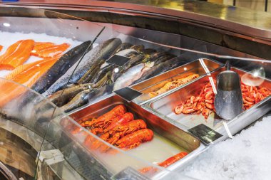 Somon, balık, ıstakoz ve marketin deniz ürünleri reyonunda buzlu karides sergilenen taze deniz ürünleri. İsveç.