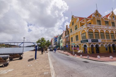 Willemstad, Curaao 'daki Ticaret İskelesi boyunca uzanan renkli tarihi binaların arkasında Kraliçe Juliana Köprüsü var.. 