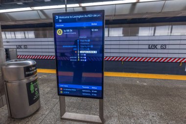 New York 'taki Lexington Av-63 St Metro istasyonundaki dijital tren tarifesi varış zamanlarını gösteriyor. - New York. ABD.