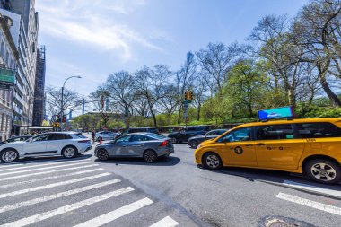 Manhattan 'da bir bahar gününde Central Park' ın yakınlarındaki kavşakta araçlarla şehir caddesi manzarası. - New York. ABD.