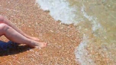 Halkidiki sahilinde kadınların sıcak çakıl taşlarına dokunması Ege Denizi 'nin berrak dalgalarıyla rahatlatıcı bir yaz havası yaratıyor..