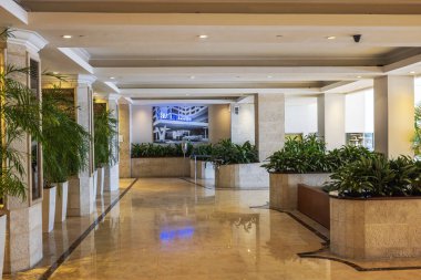 Cilalı mermer döşemeleri, yeşil bitkileri ve Barcelo tabelaları olan zarif bir otel lobisi. Miami Plajı. 