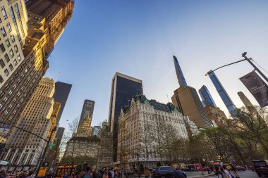 Central Park yakınlarındaki modern gökdelenler ve tarihi binalar ilkbahar akşamı ön cephelerinde altın güneş ışığı yansıyor. - New York. ABD. 