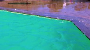 Şiddetli rüzgar, havuz suyunun ıslak fayanslara sıçramasına ve açık havuzda dalgalanmalara ve türbülansa neden olur. Girit. Yunanistan.